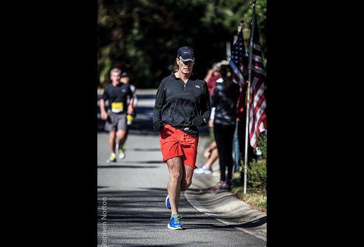 Dr. Pate running next to American flag