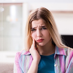 Blonde woman with oral pain looking concerned