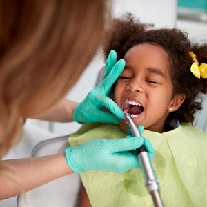 children’s dentist in Buckhead cleaning a patient’s teeth