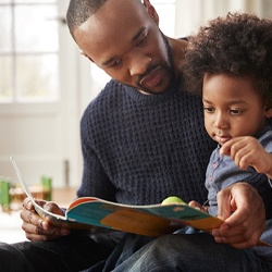 parent sitting with their child and reading a book