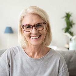 Older woman smiling after seeing emergency dentist.