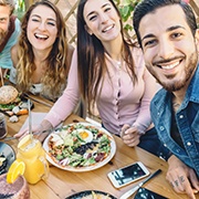 A young man and his friends enjoying an outdoor meal together in Buckhead