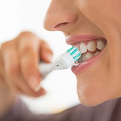 Woman brushing teeth in Buckhead