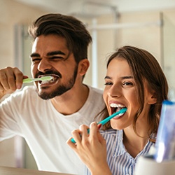 Man and woman brushing teeth