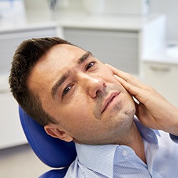 Man holding cheek in pain