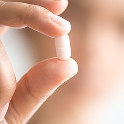 Hand holding a tablet pill