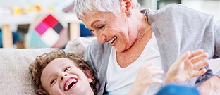 Smiling senior woman smiling at young child