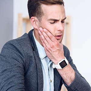 Man holding jaw in pain