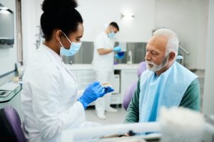 mature man discussing dentures with dentist 