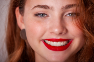 Woman with bright red lipstick smiling brightly
