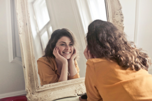 Woman looking in mirror at teeth